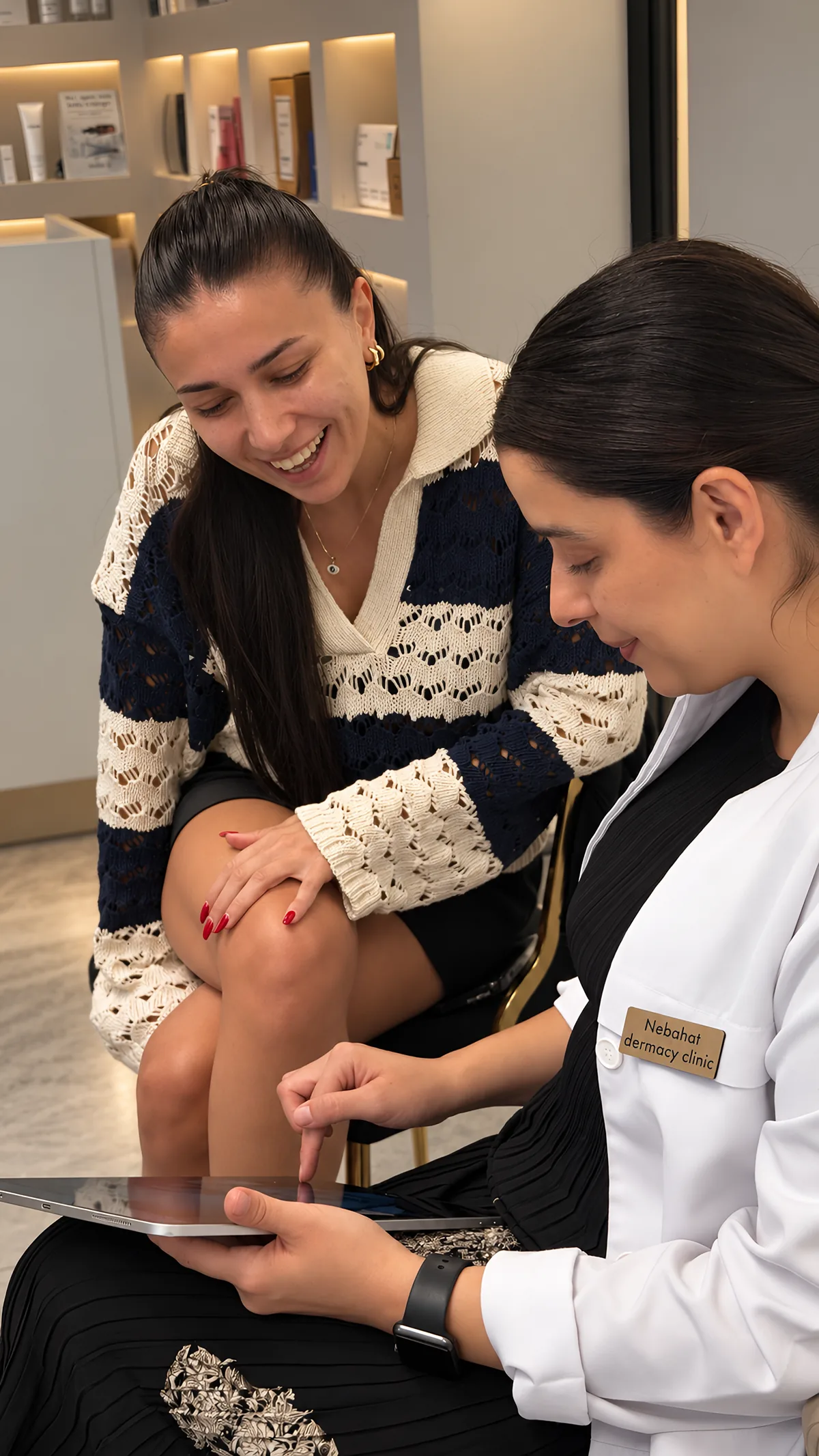 Client smiling with Nebahat as they look at her skin after HydraFacial
